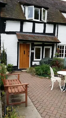 a bench and a table in front of a house at Peel Cottage, Dilwyn in Dilwyn