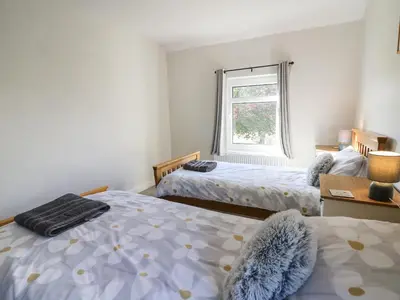 a bedroom with two beds and a window at Pengraig in Tregaron
