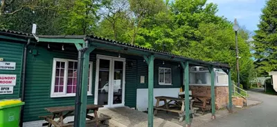 a green cabin with a picnic table in front of it at Glan yr Afon Dau - Relax Recuperate Hot Tub in Welshpool
