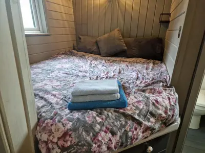 a bed with a blanket and two towels on it at Glan yr Afon Dau - Relax Recuperate Hot Tub in Welshpool
