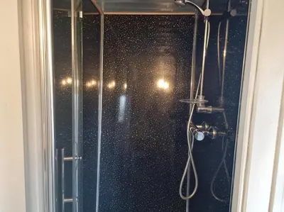 a shower with a glass door with a shower at Glan yr Afon Dau - Relax Recuperate Hot Tub in Welshpool