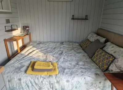 a bed in a room with a yellow towel on it at Glan yr Afon Un - Relax Recuperate Enjoy in Welshpool