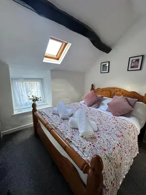 a bedroom with a bed with pillows on it at Love Lane Cottage Dolgellau in Dolgellau