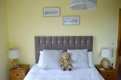 a teddy bear sitting on top of a bed at Ruby's Watch in Barmouth