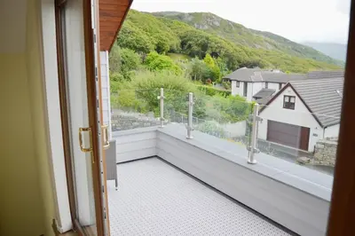 a balcony with a view of a house at Ruby's Watch in Barmouth