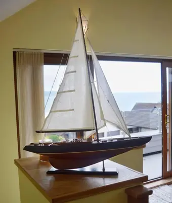 a model boat sitting on a table next to a window at Ruby's Watch in Barmouth