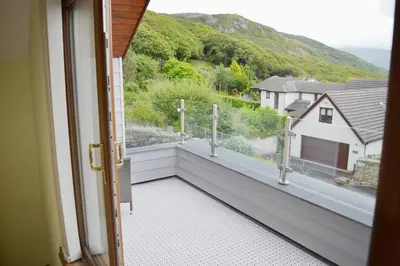 a balcony with a view of a house at Ruby's Watch in Barmouth