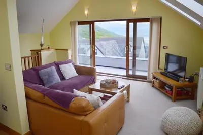 a living room with a couch and a tv at Ruby's Watch in Barmouth