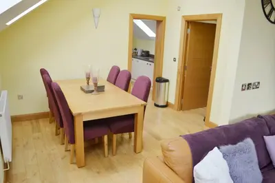a dining room with a table and purple chairs at Ruby's Watch in Barmouth