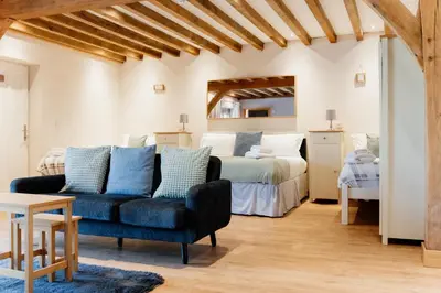 a bedroom with a bed and a couch and a table at Finest Retreats - The Welsh Barn in Aberystwyth