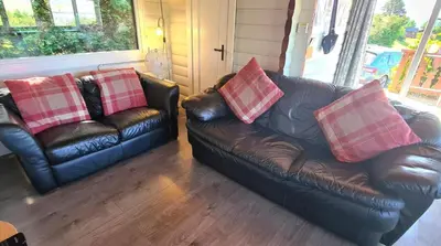 two leather couches with pillows on them in a living room at Cosy log cabin in Snowdonia 167 in Trawsfynydd