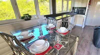 a dining room with a glass table and chairs at Cosy log cabin in Snowdonia 167 in Trawsfynydd