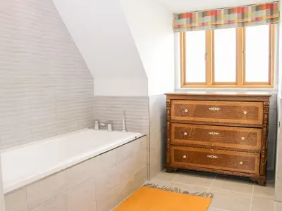 a bathroom with a bath tub and a dresser at White House in Montgomery