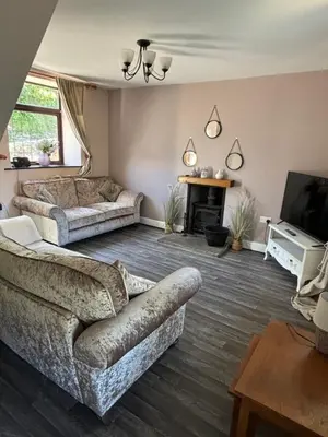 a living room with two couches and a fireplace at Glanyrafon Cottage in Sennybridge