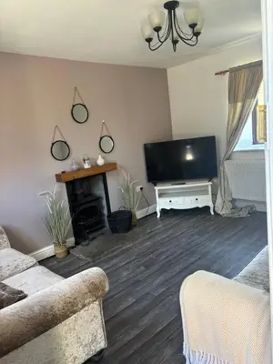 a living room with a flat screen tv and a fireplace at Glanyrafon Cottage in Sennybridge