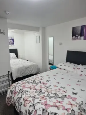 a bedroom with two beds and a bedspread with butterflies at Cosy Studio - Town centre flat with free nearby parking in Shrewsbury