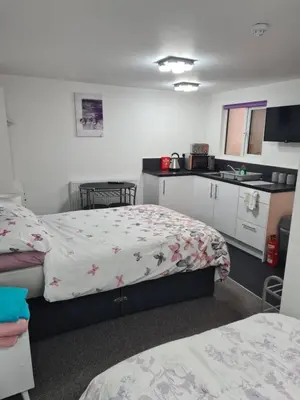 a hotel room with two beds and a kitchen at Cosy Studio - Town centre flat with free nearby parking in Shrewsbury