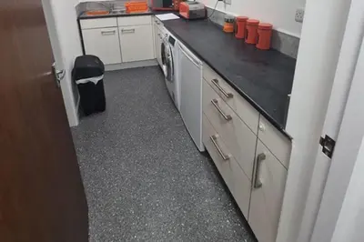 a kitchen with a black counter top and a dishwasher at Cosy Nook - Town centre flat with free nearby parking, in Shrewsbury
