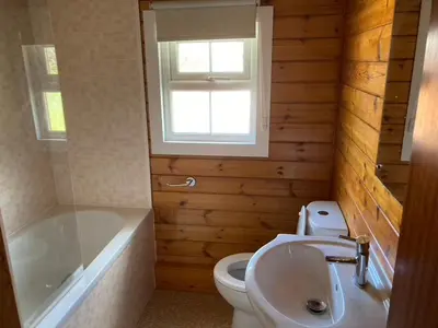 a bathroom with a toilet and a tub and a sink at Cosy log cabin in Snowdonia 357 in Trawsfynydd