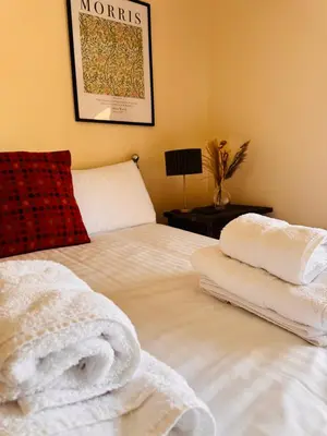 a bedroom with a bed with towels on it at The Harp Inn in Old Radnor
