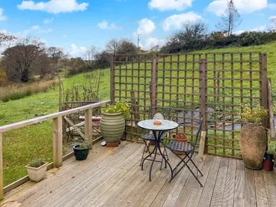 a deck with a table and chairs and a fence at The Hideaway in Tregaron