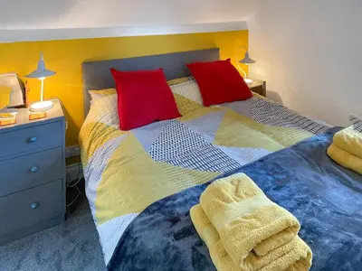 a bedroom with two beds with red and yellow pillows at The Hideaway in Tregaron
