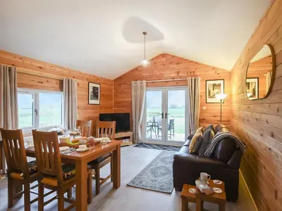 a living room with a table and a couch at Llwynog Lodge in Montgomery