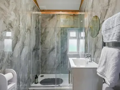 a bathroom with a shower and a sink at Llwynog Lodge in Montgomery