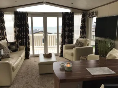 a living room with a couch and a table at Newquay Haven caravan 42x14 with Ocean Views in New Quay