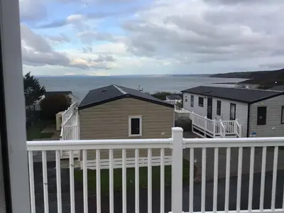 a view of the ocean from a balcony of a house at Newquay Haven caravan 42x14 with Ocean Views in New Quay