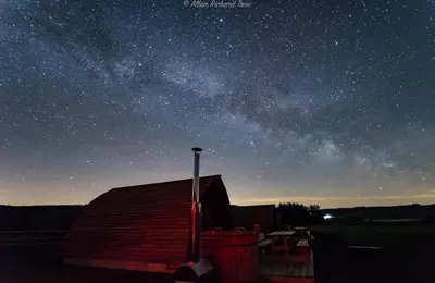a starry night with a barn and the milky way at Hafren by Wigwam Holidays in Llanbrynmair