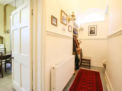 a hallway with a door and a red rug at Caynham Court in Ludlow