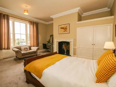 a bedroom with a large bed and a fireplace at Caynham Court in Ludlow