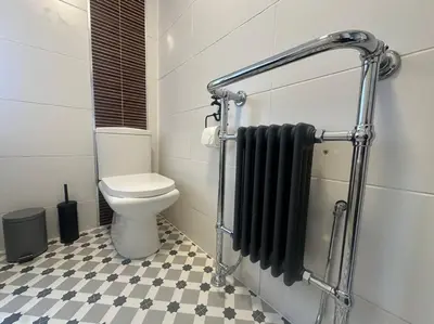 a bathroom with a toilet and black towels at Charming newly renovated 3 bed cottage in Brecon town with private garden & pets welcome in Brecon