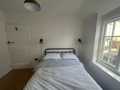 a white bedroom with a bed with two pillows at Charming newly renovated 3 bed cottage in Brecon town with private garden & pets welcome in Brecon