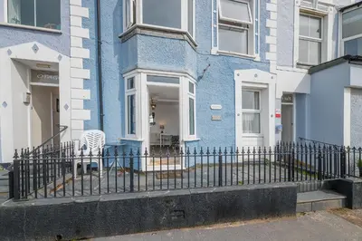 a blue house with a zebra chair in front of it at 2 Bed Ground Floor Beach Location in Aberdyfi