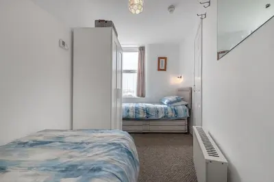a bedroom with a bed and a mirror at 2 Bed Ground Floor Beach Location in Aberdyfi