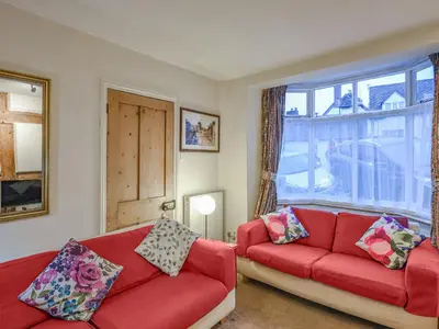 a living room with two red couches and a window at Paul Pry in Ludlow