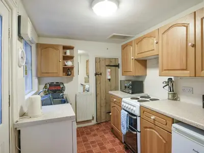 a kitchen with wooden cabinets and white appliances at Paul Pry in Ludlow