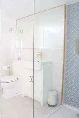 a bathroom with a toilet and a glass shower at Harbourside luxury house in Aberaeron