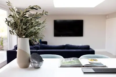 a white vase with a plant on a table at Harbourside luxury house in Aberaeron