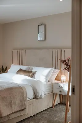 a bedroom with a large white bed with a night stand at 2 Bed Apartment Overlooking the Square Step Out to Shops & Dining in Shrewsbury