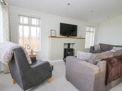 a living room with two couches and a fireplace at Seren Lodge in Builth Wells