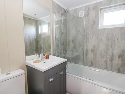 a bathroom with a sink and a shower and a tub at Seren Lodge in Builth Wells