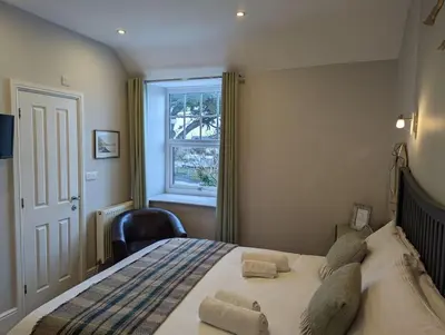 a bedroom with a large bed with a window at Cartref Guesthouse - Room 2 Ensuite in Aberdyfi