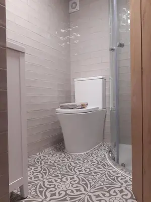 a white bathroom with a toilet and a shower at Jasmine Cottage in Shrewsbury