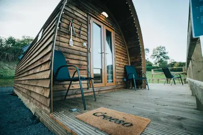 a house with chairs and a rug on a deck at Knighton by Wigwam Holidays in Knighton