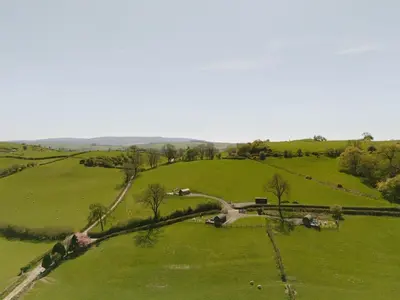 an aerial view of a green field with animals in it at Knighton by Wigwam Holidays in Knighton