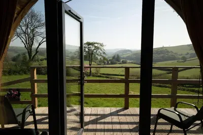 a room with a view of a field through a glass door at Knighton by Wigwam Holidays in Knighton