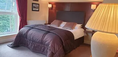 a bedroom with a large bed with two lamps at Usk And Railway Inn in Sennybridge